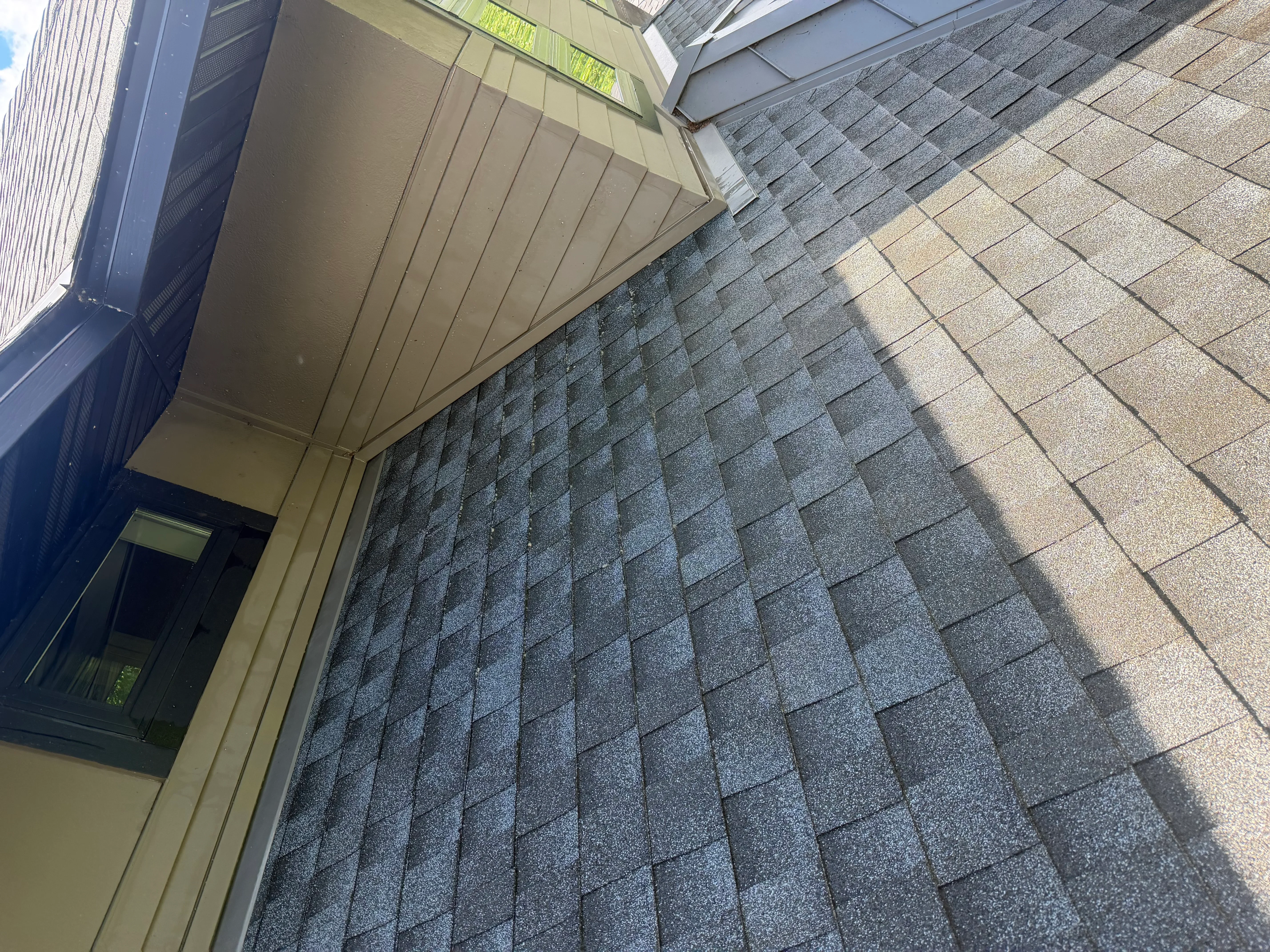 Cleaned asphalt shingle roof with gray and tan shingles, soffit and fascia visible