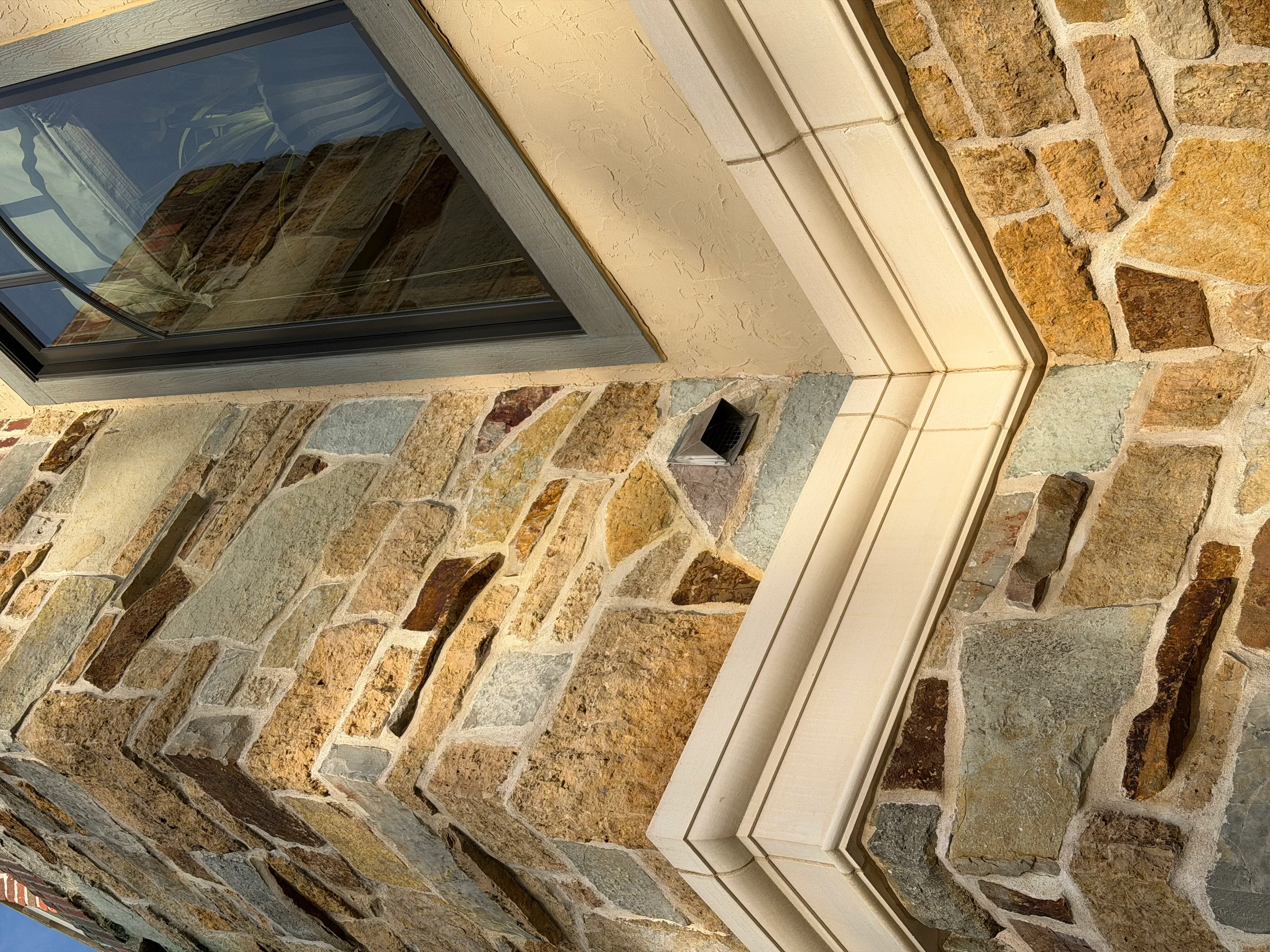 Cleaned stacked stone veneer with white trim and window frame
