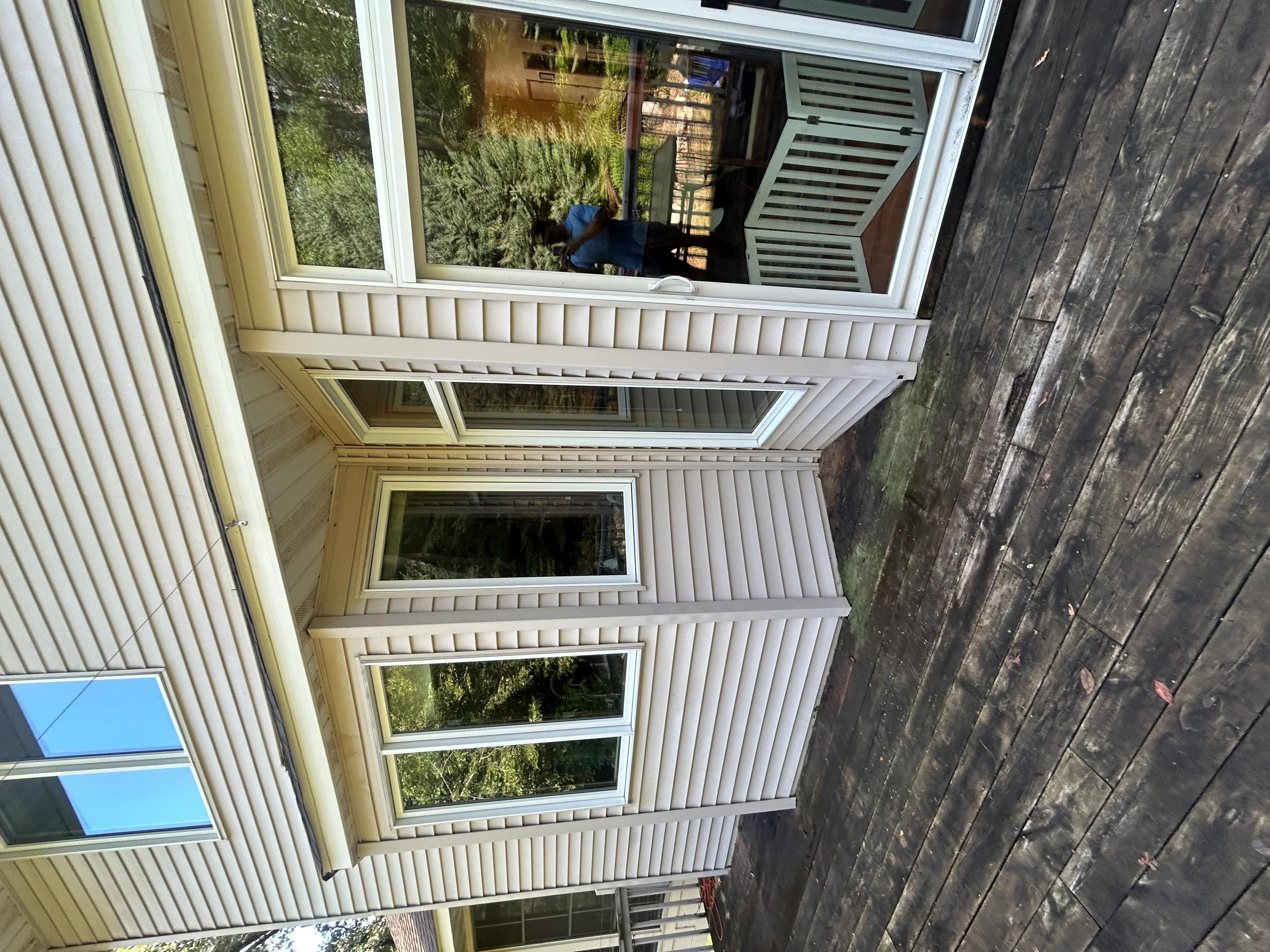 White vinyl siding and window frames cleaned on residential home exterior
